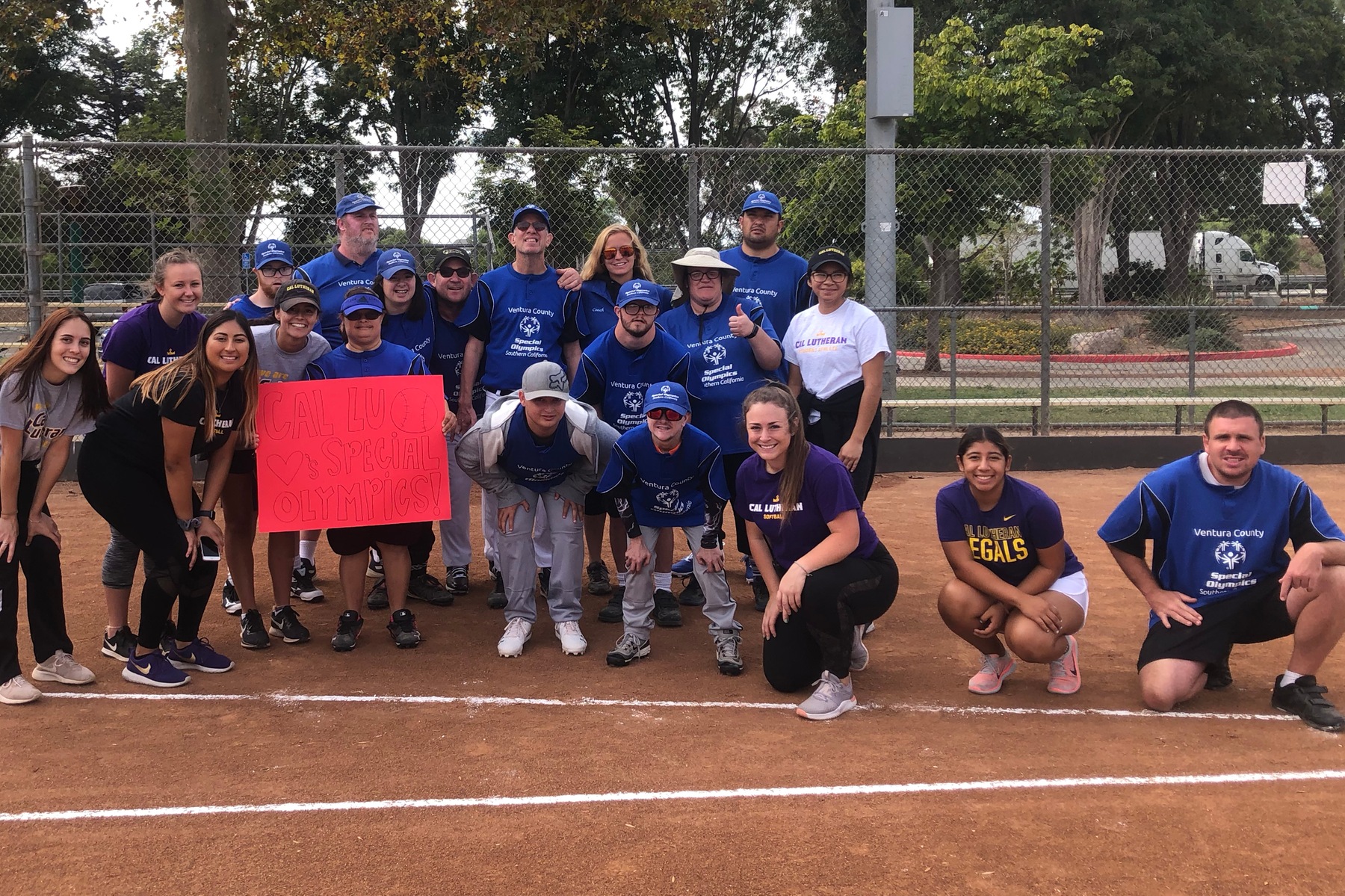 Marinesi (middle and on a knee) and six teammates host Ventura County Special Olympics Softball Clinic.